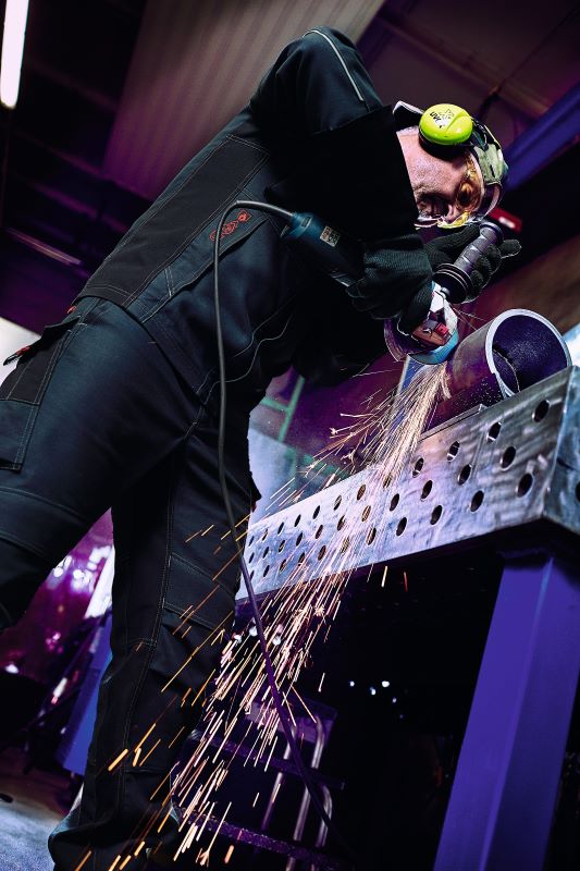 Un homme est en train de souder et porte un équipement de protection pour soudeurs conforme à l'en iso 11611.